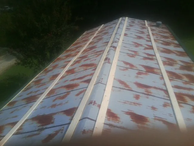 Rusted metal roof panels with new wood purlins before replacement — Storm Damage Roof Repair in North Franklin by Roofing Brothers
