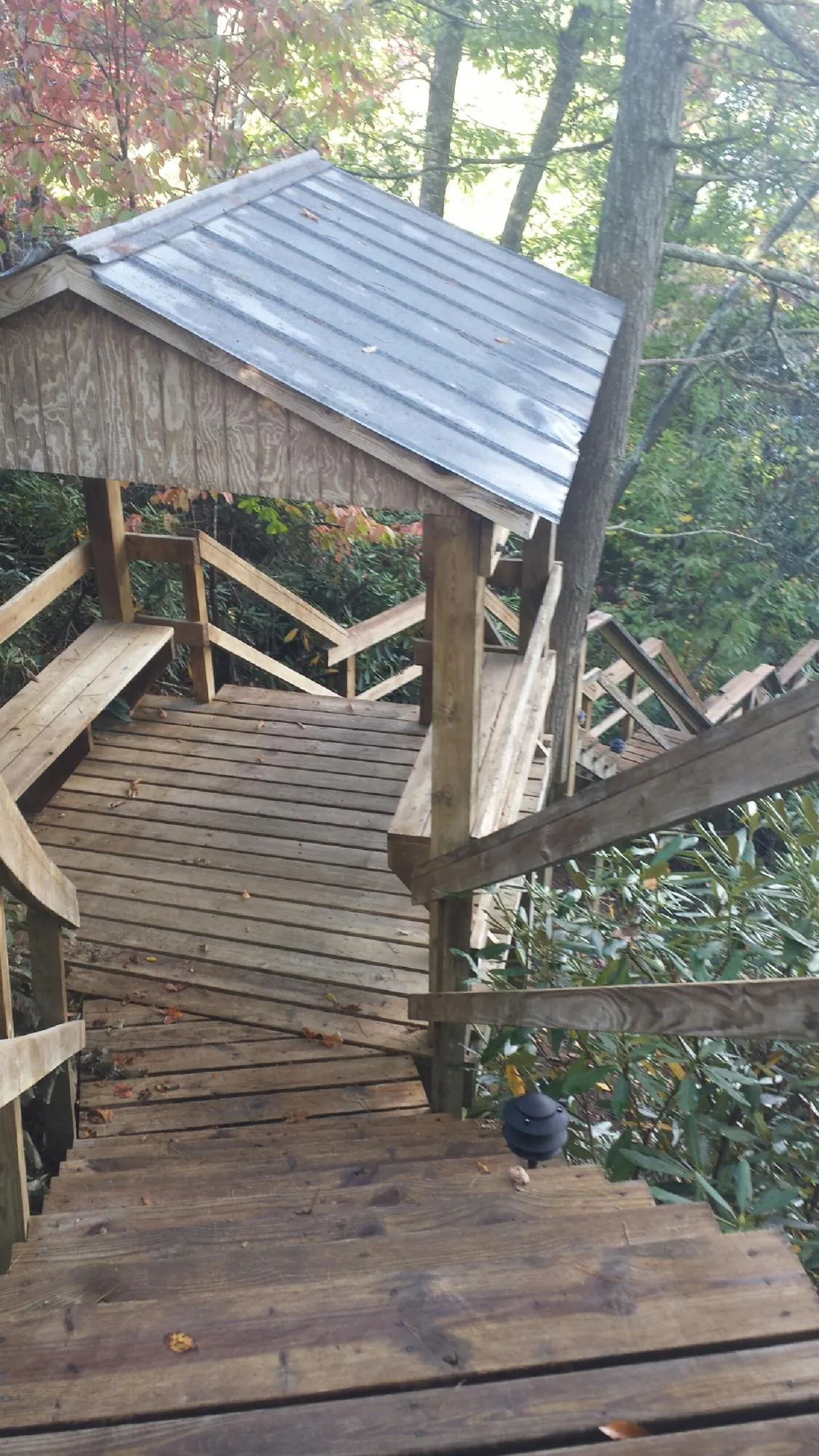 Metal roofed shelter over wooden steps on a wooded walkway — Skylight Repair & Installation work by our crew in North Franklin