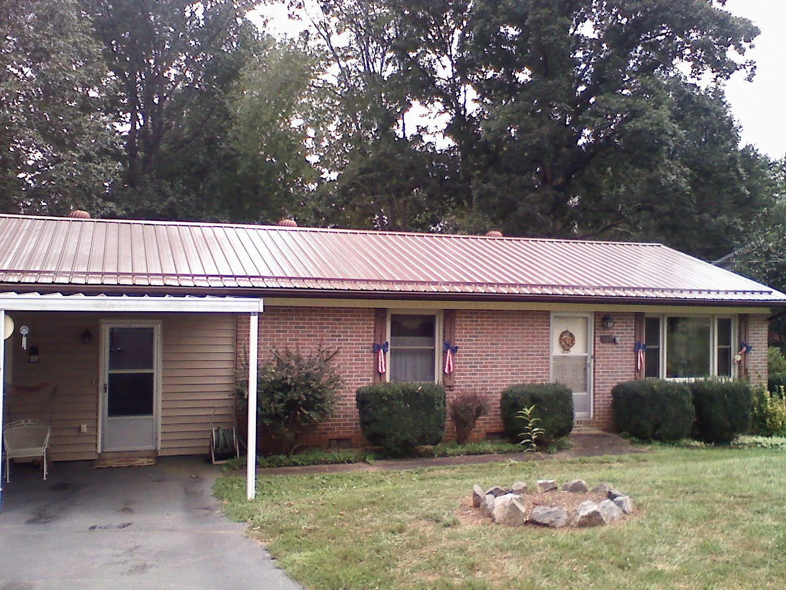 Bronze metal roof and carport on a brick ranch home — Roof Repair work by our crew in North Franklin